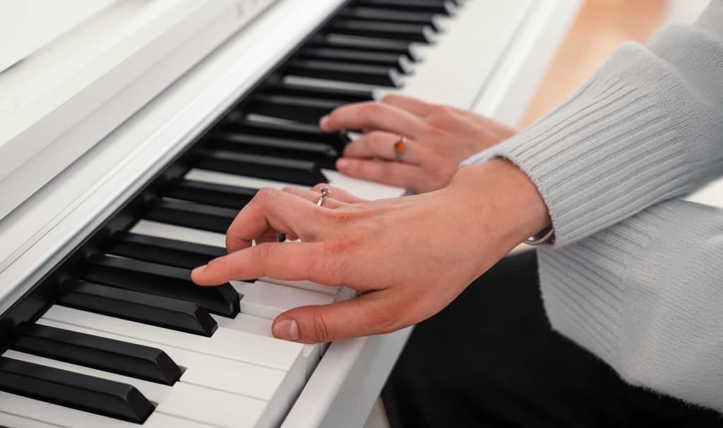 Hands playing a Kawai CX102
