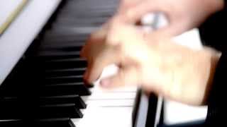 Hands playing a Kawai upright piano