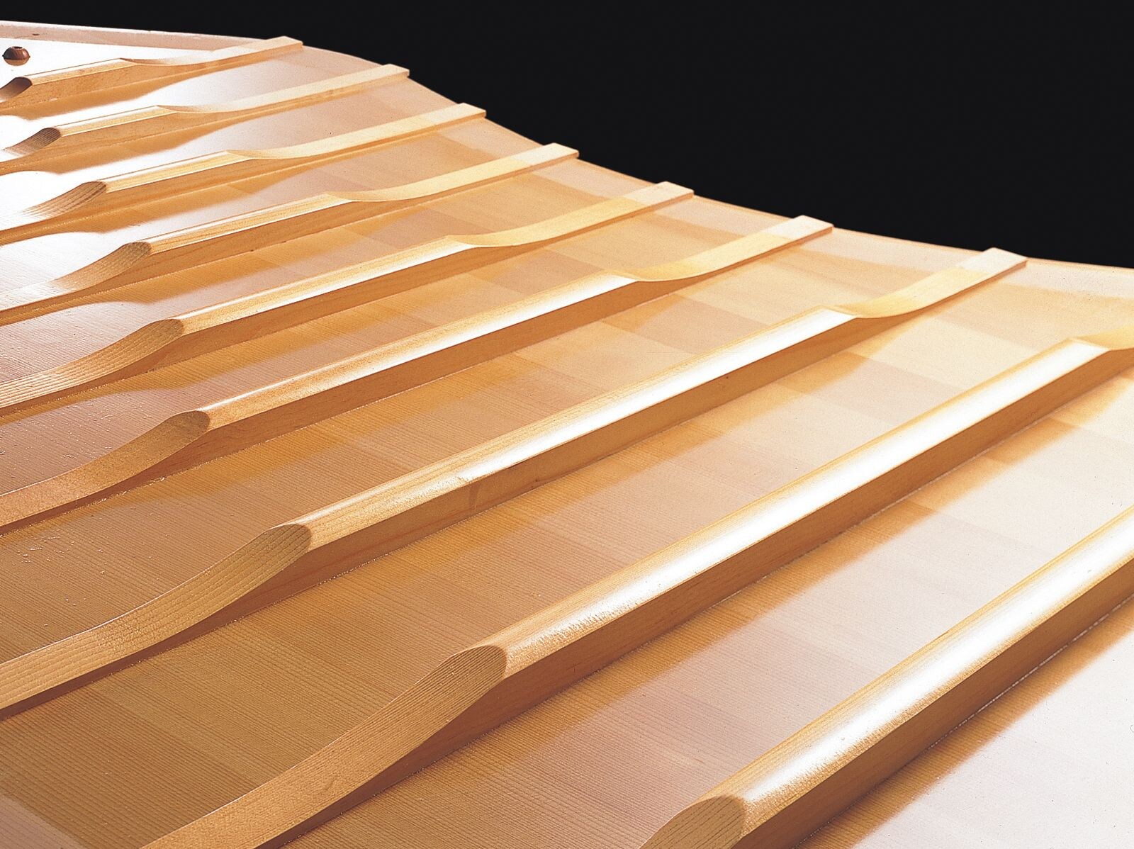Wooden ribs extending across a Yamaha grand piano soundboard