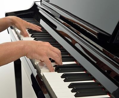 Hands playing the GrandTouch-S keyboard of a Yamaha digital piano
