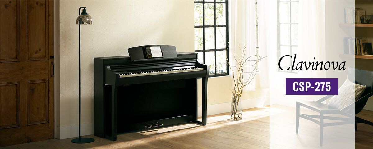 A Yamaha Clavinova CSP-275 digital piano in a bright living room.