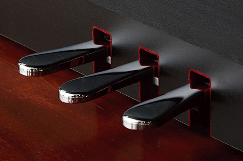 Close-up of the three pedals on a Yamaha Clavinova piano.