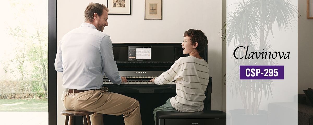 A man and young boy playing a Yamaha Clavinova CSP-295 digital piano together.