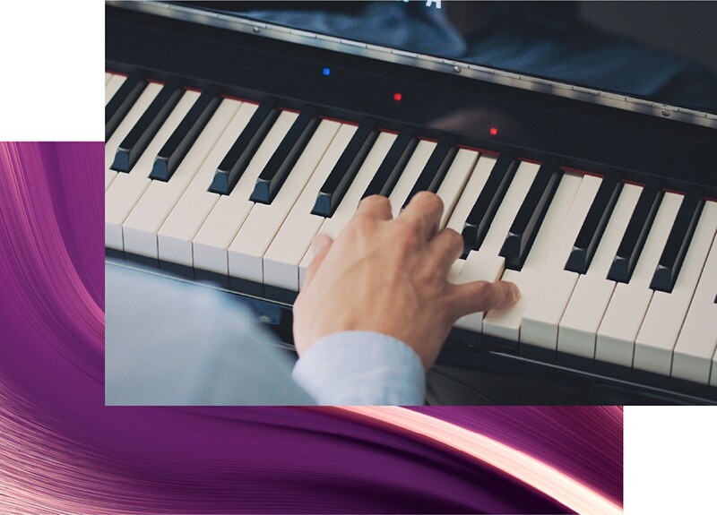 A hand playing a Yamaha Clavinova keyboard with Stream Lights illuminated.