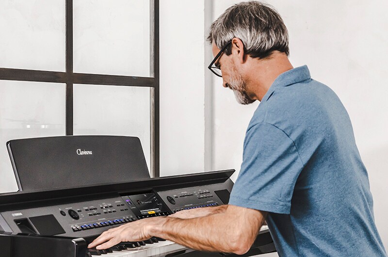 A person playing the Yamaha CVP-905 Clavinova keyboard