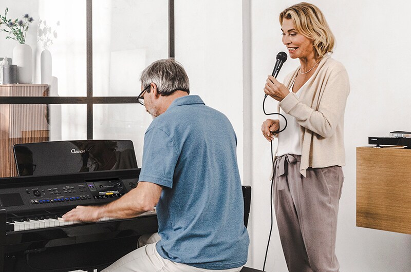 A couple enjoying singing along with a Clavinova piano