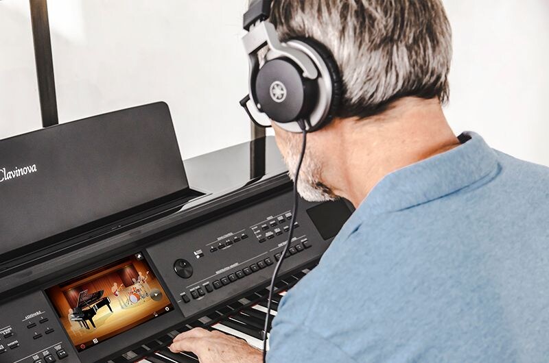 A person using the Clavinova display while playing piano