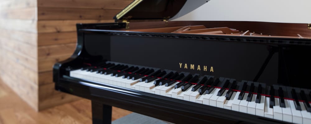Yamaha Disklavier piano with its keyboard and gold Yamaha logo.