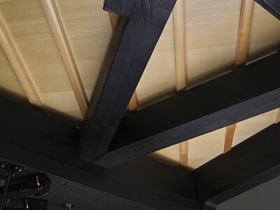 Structural beams beneath a Yamaha grand piano soundboard.