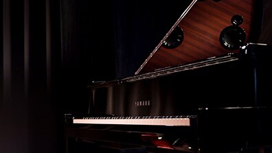 Yamaha N3X AvantGrand hybrid grand piano in a dimly lit setting.