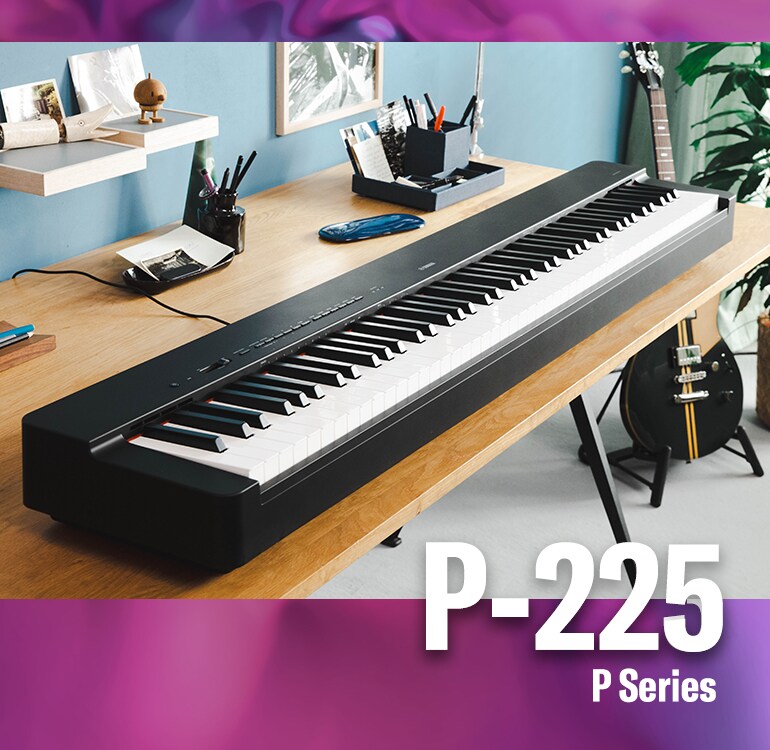 Yamaha P-225 digital piano on a wooden desk.