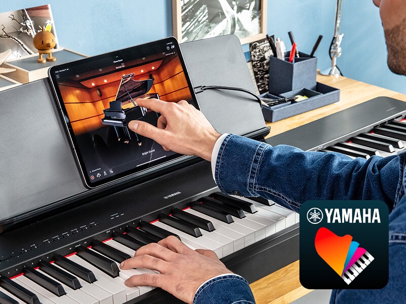 A tablet showing the Yamaha Smart Pianist app beside a P-225 piano.