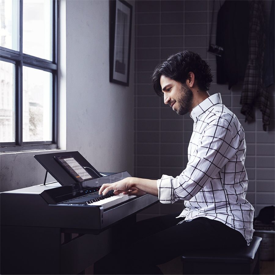 A person playing a black Yamaha P-S500 Portable Digital Smart Piano