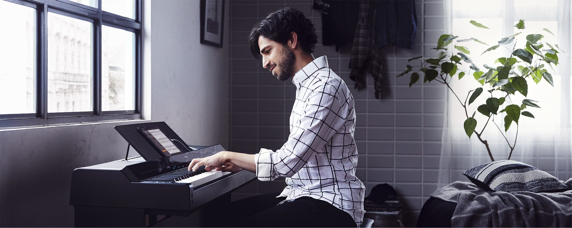 A person playing a Yamaha P-S500 Portable Digital Smart Piano in a modern room