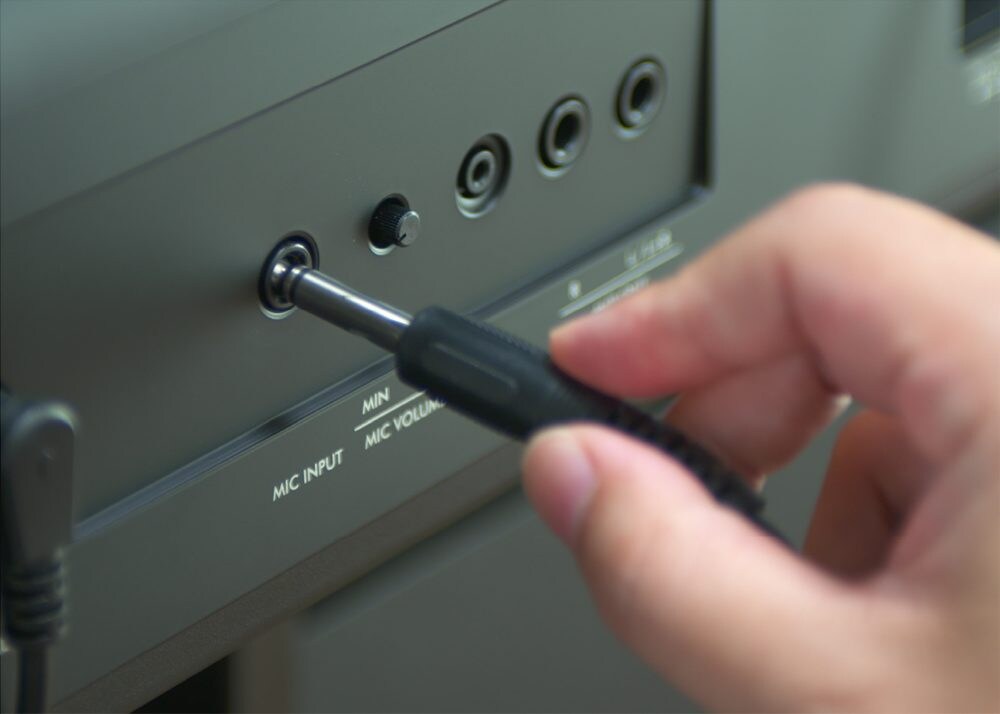 A microphone cable being inserted into the Yamaha P-S500 MIC INPUT