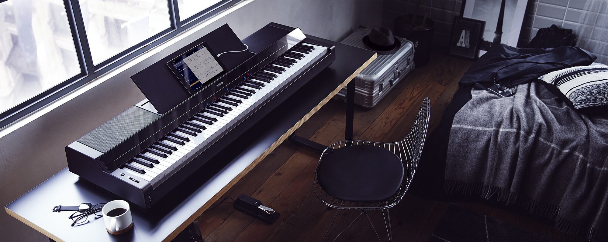 A Yamaha P-S500 Portable Digital Smart Piano on a desk with a tablet
